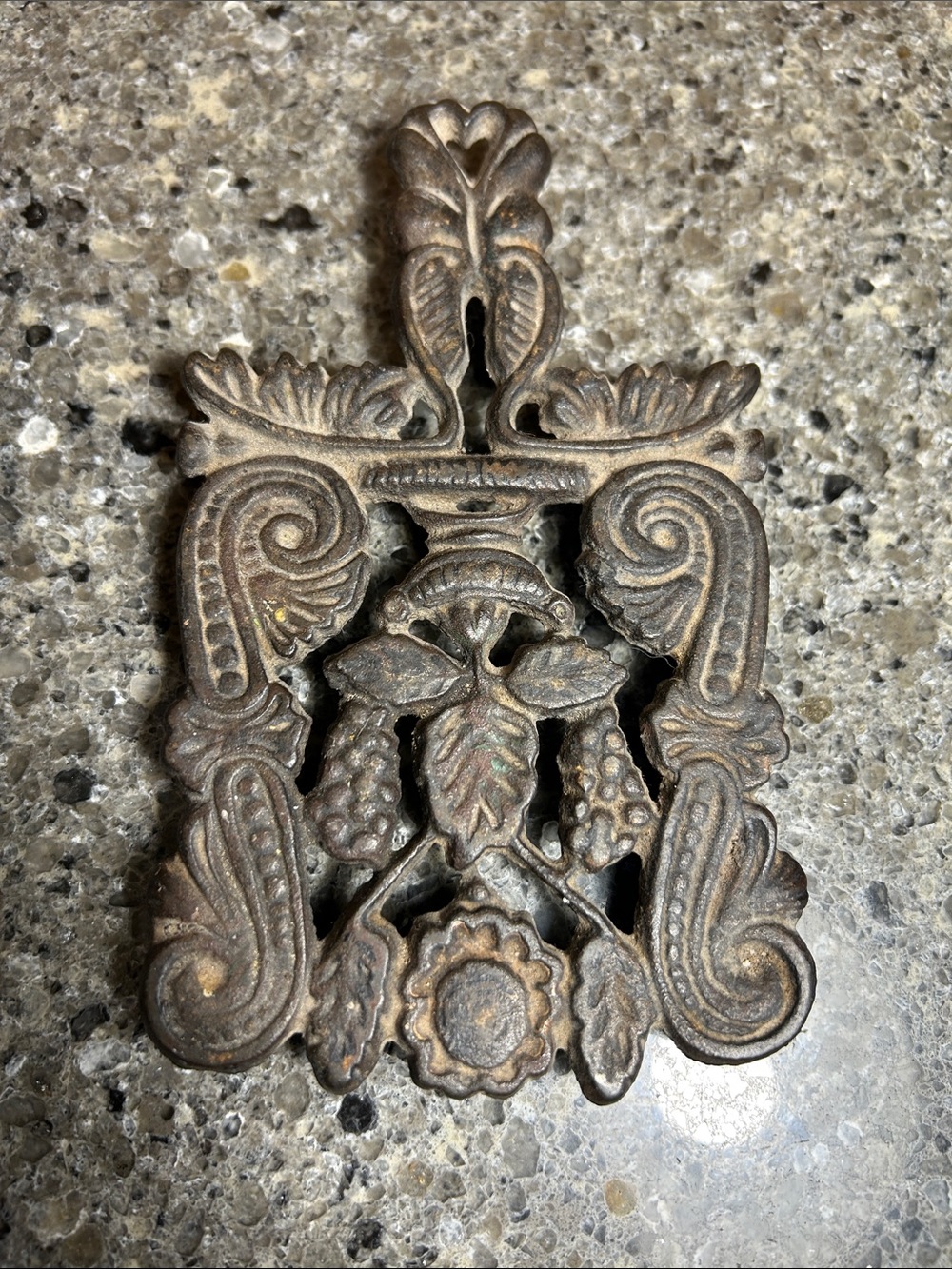 Iron trivet with decorative floral pattern